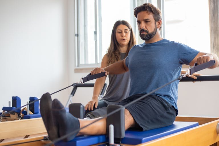 A Man In Blue Shirt Exercising with Supervision