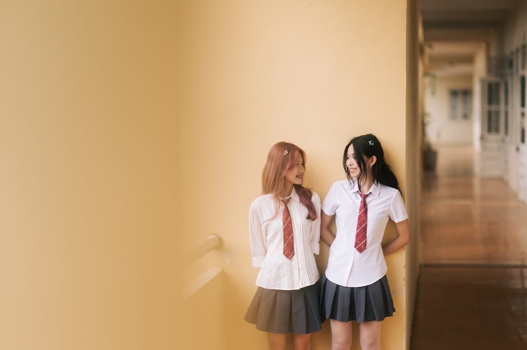 Two girls in school uniforms standing next to each other